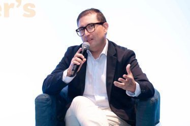 Foto de Erik Díaz sentado con micrófono en mano exponiendo