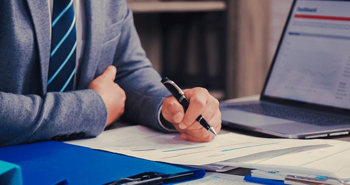 Plano medio de persona escribiendo en un cuaderno sobre un escritorio