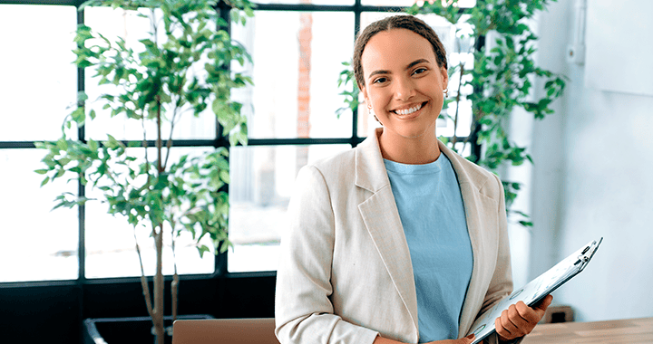 Mujer de pie sonriendo a la cámara