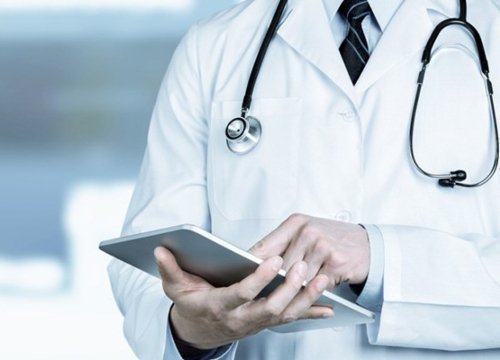 Torso de un médico con implementos médicos sosteniendo una tablet