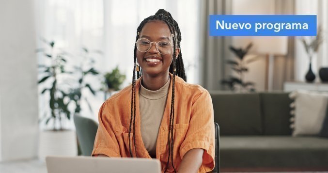 Mujer joven sonriente con gafas trabajando en un portátil; aparece un cartel "Nuevo programa" en la esquina.