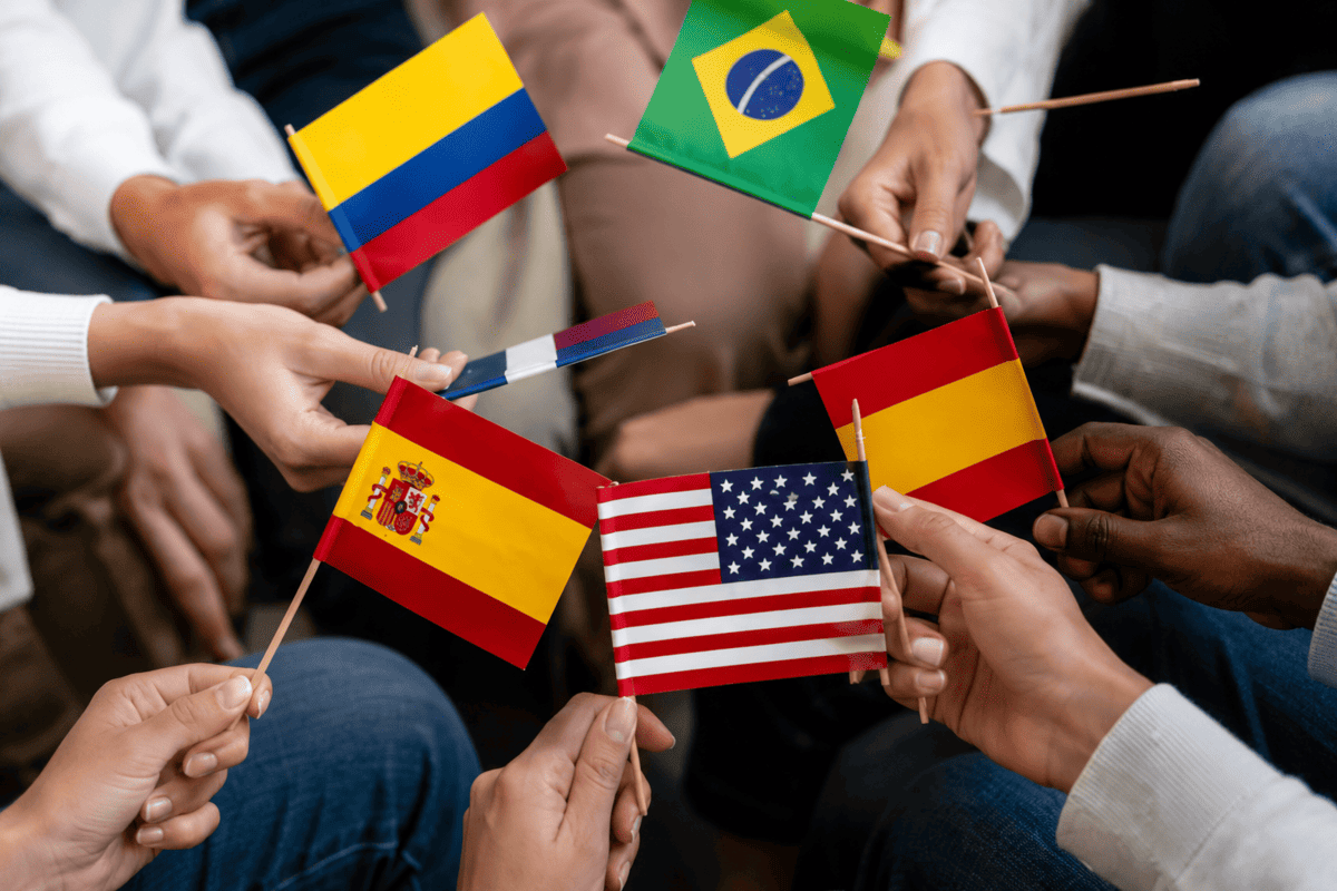 Personas sosteniendo banderas de distintos países como símbolo de intercambio cultural e internacionalización.