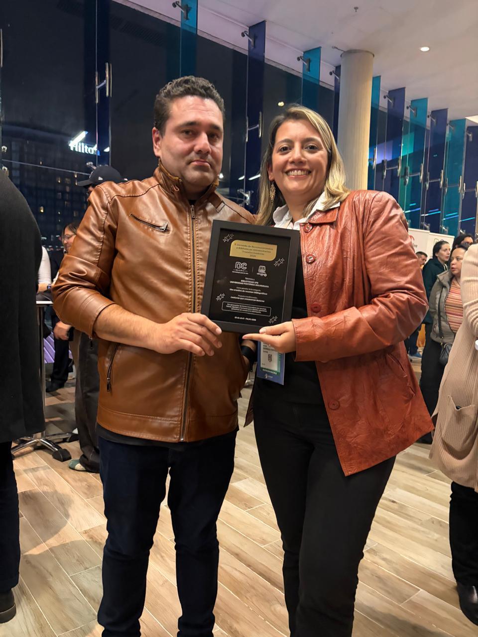 Paola Sierra, directora del Sistema de Bibliotecas UPB y Luis Salazar, bibliotecólogo de la Biblioteca Central con el premio