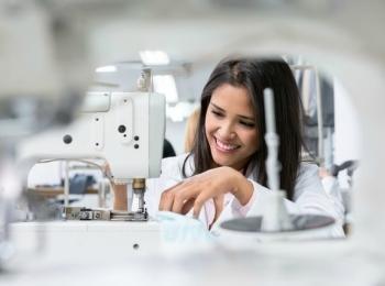 Estudiante confeccionando en máquina de coser